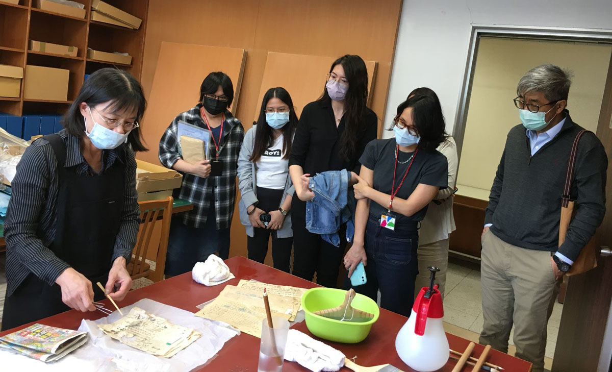 雷祥麟所長(右一)與師長同仁正觀看檔案裱褙修復作業。