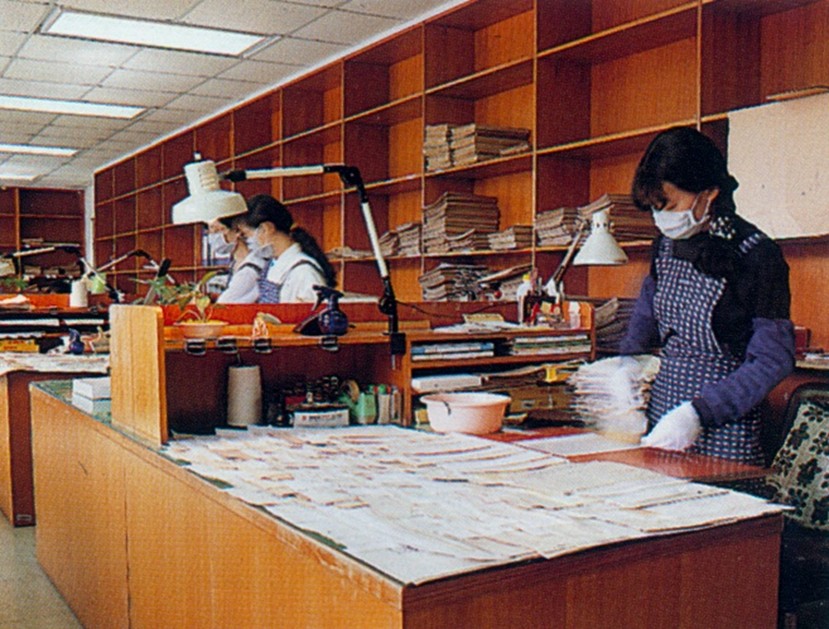 本館四樓編目工作室工作情況略圖。助理連雪琄小姐（右）正進行裱褙之工作，左方同仁在分類及討論。